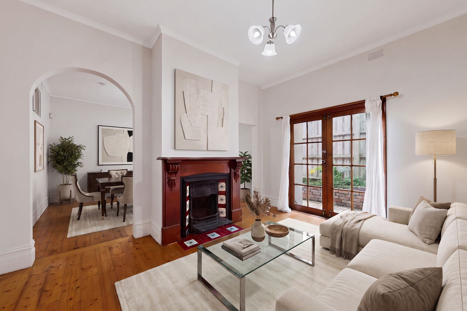 Transitional virtual staging of a period living room with a fireplace and cream armchairs