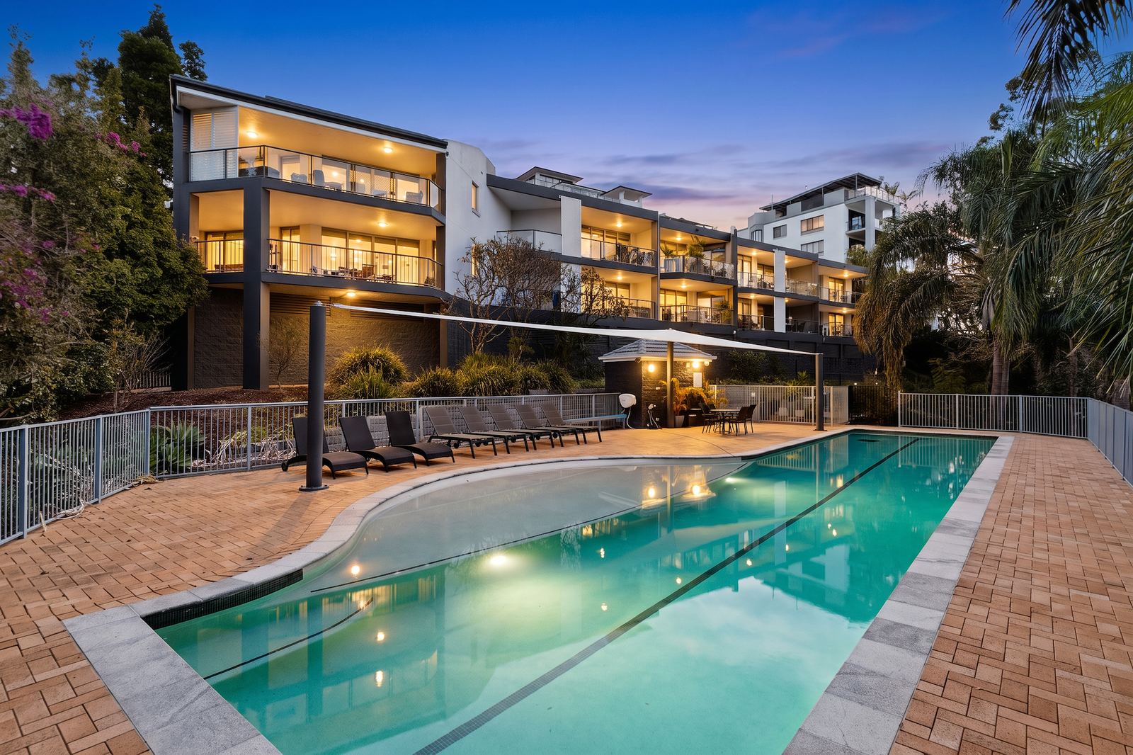 Virtual Staging Services 5 Day to dusk conversion of an apartment building and pool, lit at twilight