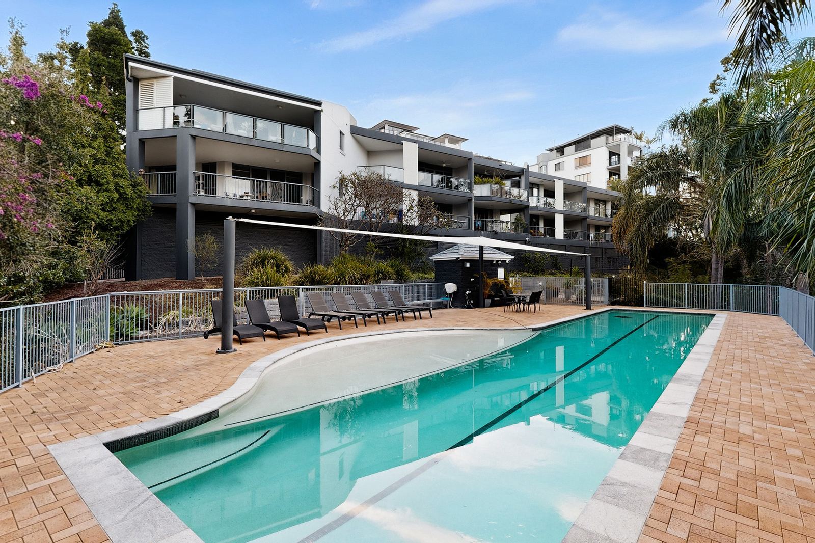 Virtual Staging Services 6 Apartment building and pool photographed at midday before day to dusk conversion