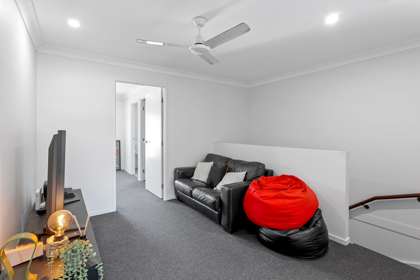 Virtual Staging Services 8 Occupied lounge with a dark leather sofa and clutter before virtual furniture removal